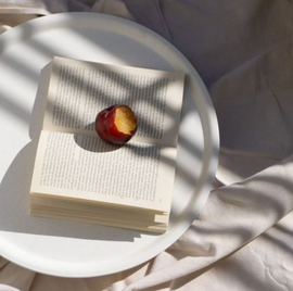 Book with a peach on a white surface