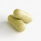 Two green capsules on a white background